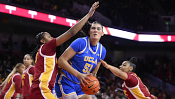 Feb 13, 2025; Los Angeles, California, USA; UCLA Bruins center Lauren Betts (51) drives to the basket between USC Trojans guard Aaliyah Gayles (3) and guard JuJu Watkins (12) during the first quarter at Galen Center.