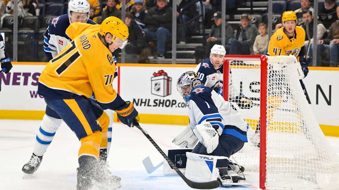 Nov 29, 2025; Nashville, Tennessee, USA;  Winnipeg Jets goaltender Eric Comrie (1) makes a save against Nashville Predators right wing Matthew Wood (71) during the first period at Bridgestone Arena. Mandatory Credit: Steve Roberts-Imagn Images