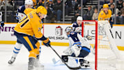 Nov 29, 2025; Nashville, Tennessee, USA;  Winnipeg Jets goaltender Eric Comrie (1) makes a save against Nashville Predators right wing Matthew Wood (71) during the first period at Bridgestone Arena. Mandatory Credit: Steve Roberts-Imagn Images