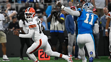 Aug 8, 2025; Charlotte, North Carolina, USA; Cleveland Browns quarterback Shedeur Sanders (12) scrambles as Carolina Panthers linebacker Nic Scourton (11) pressures in the second quarter at Bank of America Stadium. Mandatory Credit: Bob Donnan-Imagn Images