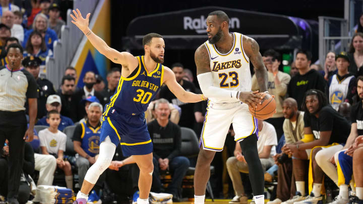 Los Angeles Lakers forward LeBron James (23) handles the ball against Golden State Warriors guard Stephen Curry.