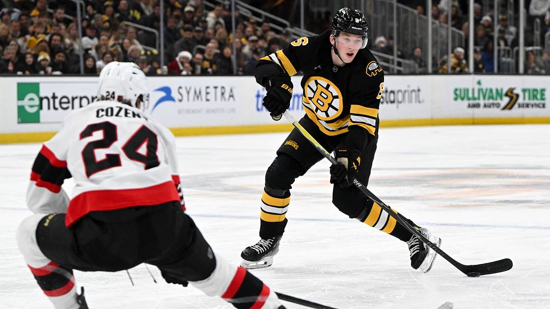 Dec 21, 2025; Boston, Massachusetts, USA; Boston Bruins defenseman Mason Lohrei #6 passes the puck against Ottawa Senators center Dylan Cozens #24 during the third period at the TD Garden. Mandatory Credit: Brian Fluharty-Imagn Images