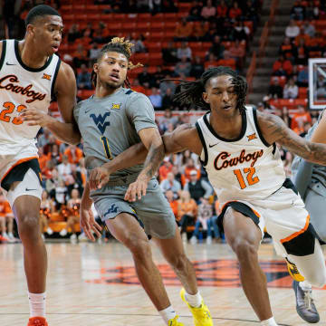 Jan 27, 2024; Stillwater, Oklahoma, USA; Oklahoma State Cowboys guard Javon Small (12) drives to the basket against West Virginia Mountaineers guard Noah Farrakhan (1) during the first half at Gallagher-Iba Arena. Mandatory Credit: William Purnell-USA TODAY Sports