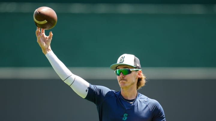 Seattle Mariners starting pitcher Bryce Miller (50) throws a football prior to a game against the Kansas City Royals at Kauffman Stadium on June 9.