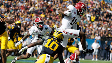 Dec 31, 2024; Tampa, FL, USA; Alabama Crimson Tide wide receiver Rico Scott (11) leaps over wide receiver Ryan Williams (2) and Michigan Wolverines defensive back Zeke Berry (10) during the first half at Raymond James Stadium. Mandatory Credit: Matt Pendleton-Imagn Images
