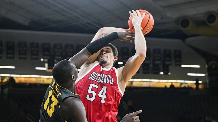 Nov 12, 2024; Iowa City, Iowa, USA; South Dakota Coyotes center Cameron Fens (54) is defended by Iowa Hawkeyes forward Ladji Dembele (13) during the first half at Carver-Hawkeye Arena. Mandatory Credit: Jeffrey Becker-Imagn Images
