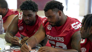 Oklahoma Sooners defensive lineman Damonic Williams signs posters during Meet the Sooners Day