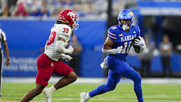 Aug 23, 2025; Lawrence, Kansas, USA; Kansas Jayhawks tight end DeShawn Hanika (18) runs with the ball against Fresno State Bulldogs linebacker Jadon Pearson (39) during the second half at David Booth Kansas Memorial Stadium. Mandatory Credit: Jay Biggerstaff-Imagn Images