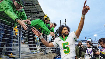 The sky's the limit: quarterback Dante Moore celebrates with fans after Oregon's 26-14 win over Washington Saturday.