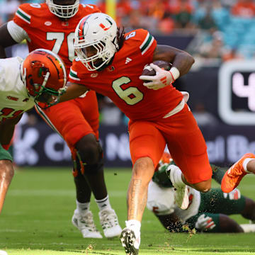 Sep 7, 2024; Miami Gardens, Florida, USA; Miami Hurricanes running back Damien Martinez (6) runs with the football against Florida A&M Rattlers defensive back Deco Wilson (11) at Hard Rock Stadium. Mandatory Credit: Sam Navarro-Imagn Images