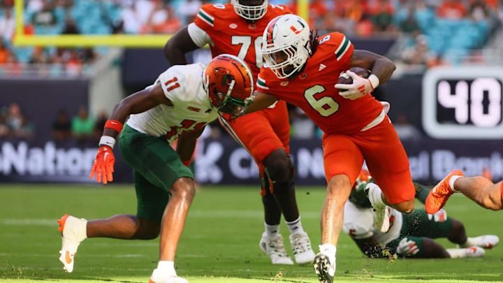 Sep 7, 2024; Miami Gardens, Florida, USA; Miami Hurricanes running back Damien Martinez (6) runs with the football against Florida A&M Rattlers defensive back Deco Wilson (11) at Hard Rock Stadium. Mandatory Credit: Sam Navarro-Imagn Images