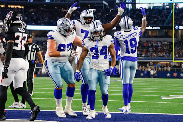 Teammates celebrate with Dallas Cowboys running back Jaydon Blue after he scores a touchdown against the Atlanta Falcons.