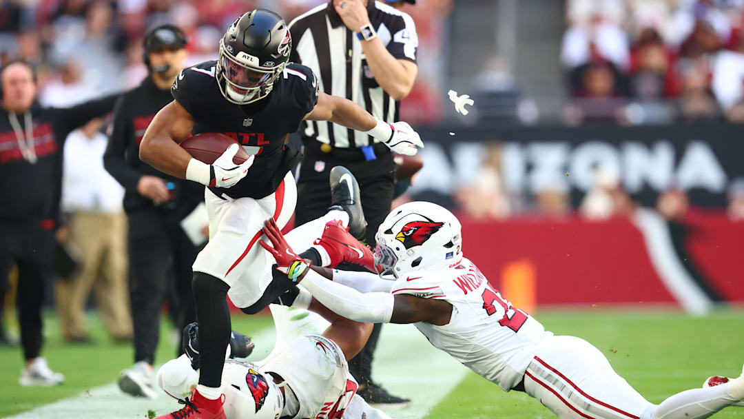 Dec 21, 2025; Glendale, Arizona, USA;  Atlanta Falcons running back Bijan Robinson (7) is pushed out of bounds by Arizona Cardinals cornerback Garrett Williams (21) and linebacker Cody Simon (50) during the first half at State Farm Stadium. Mandatory Credit: Mark J. Rebilas-Imagn Images