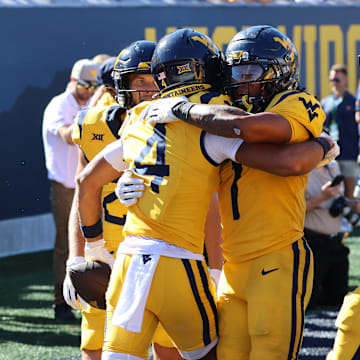 West Virginia University receiver Cam Vaughn (4) celebrates his first touchdown of the season with teammate Jahiem White (1)