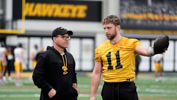 Iowa's senior football analyst Warren Ruggiero, left, talks to quarterback Mark Gronowski (11) during practice Thursday, April 3, 2025 in Iowa City, Iowa.