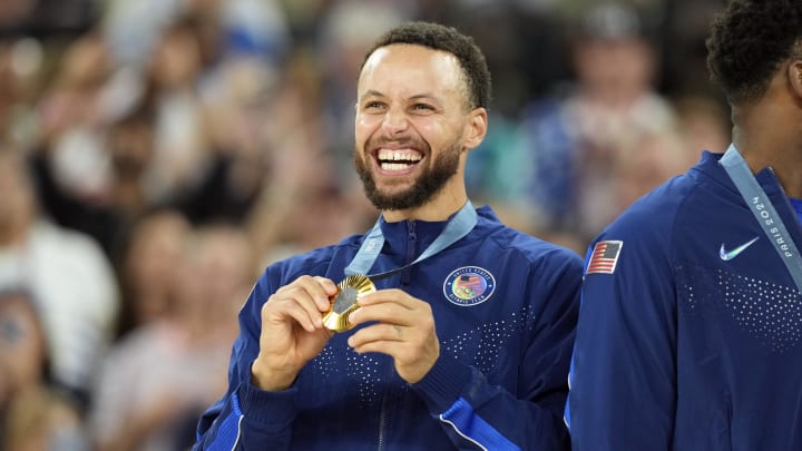 Aug 10, 2024; Paris, France; United States shooting guard Stephen Curry (4) celebrates with the gold medal after the game against France in the men's basketball gold medal game during the Paris 2024 Olympic Summer Games at Accor Arena. 