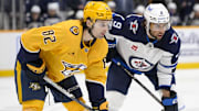 Feb 27, 2025; Nashville, Tennessee, USA;  Nashville Predators center Tommy Novak (82) and Winnipeg Jets left wing Alex Iafallo (9) await the face off during the first period at Bridgestone Arena. Mandatory Credit: Steve Roberts-Imagn Images