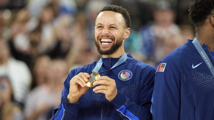 United States shooting guard Stephen Curry (4) celebrates with the gold medal after the game against France in the men's basketball gold medal game during the Paris 2024 Olympic Summer Games at Accor Arena. Mandatory Credit: