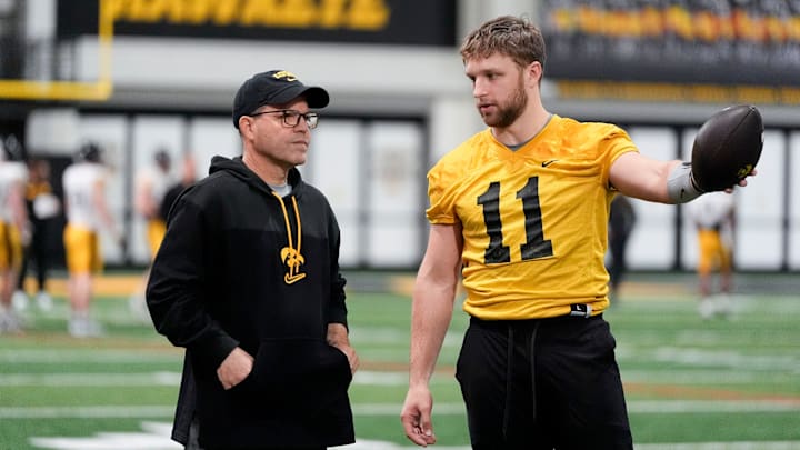 Iowa's senior football analyst Warren Ruggiero, left, talks to quarterback Mark Gronowski (11) during practice Thursday, April 3, 2025 in Iowa City, Iowa.