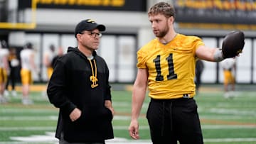 Iowa's senior football analyst Warren Ruggiero, left, talks to quarterback Mark Gronowski (11) during practice Thursday, April 3, 2025 in Iowa City, Iowa.