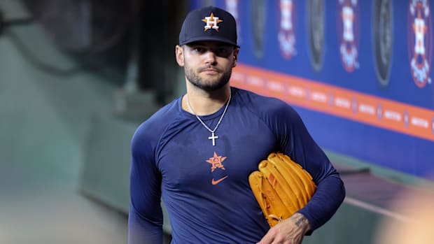 Houston Astros pitcher Lance McCullers walks in the dugout wearing a blue undershirt and blue hat.