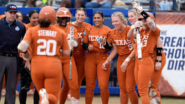 Texas players greet Katie Stewart (20) at home plate after she hit a home run in the in the sixth inning of a Women's College World Series softball game between the Texas Longhorns and the Florida Gators at Devon Park in Oklahoma City, Thursday, May 29, 2025.