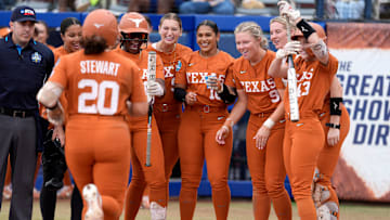Texas players greet Katie Stewart (20) at home plate after she hit a home run in the in the sixth inning of a Women's College World Series softball game between the Texas Longhorns and the Florida Gators at Devon Park in Oklahoma City, Thursday, May 29, 2025.