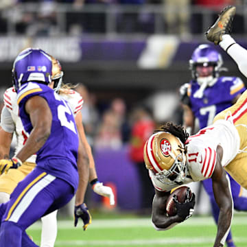 Oct 23, 2023; Minneapolis, Minnesota, USA; San Francisco 49ers wide receiver Brandon Aiyuk (11) is tackled during the second quarter as Minnesota Vikings cornerback Akayleb Evans (21) looks on at U.S. Bank Stadium. Mandatory Credit: Jeffrey Becker-Imagn Images