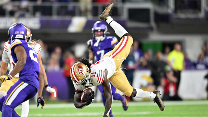 Oct 23, 2023; Minneapolis, Minnesota, USA; San Francisco 49ers wide receiver Brandon Aiyuk (11) is tackled during the second quarter as Minnesota Vikings cornerback Akayleb Evans (21) looks on at U.S. Bank Stadium. Mandatory Credit: Jeffrey Becker-Imagn Images