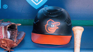 Apr 21, 2024; Kansas City, Missouri, USA; Baltimore Orioles hat and glove sits in the dugout during the ninth inning against the Kansas City Royals at Kauffman Stadium. Mandatory Credit: William Purnell-Imagn Images