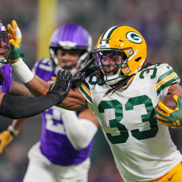 Dec 31, 2023; Minneapolis, Minnesota, USA; Green Bay Packers running back Aaron Jones (33) runs with the ball against the Minnesota Vikings safety Josh Metellus (44) in the first quarter at U.S. Bank Stadium.