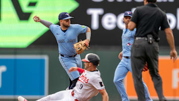 Jun 7, 2025; Minneapolis, Minnesota, USA; Toronto Blue Jays shortstop Bo Bichette (11) turns the double play off a ball hit by Minnesota Twins shortstop Carlos Correa (4) retiring outfielder Trevor Larnach (9) in the first inning at Target Field. Mandatory Credit: Matt Blewett-Imagn Images