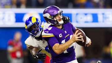 Minnesota Vikings quarterback Sam Darnold takes a hit from the LA Rams' Jared Verse