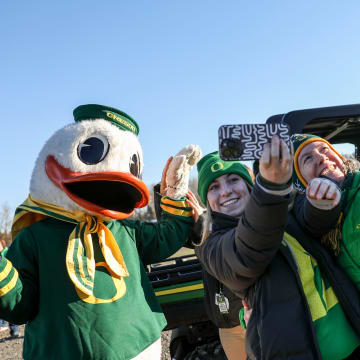 The Duck takes photos with with Oregon fans as they tailgate before the annual rivalry game on Friday, Nov. 24, 2023 at Autzen Stadium in Eugene, Ore.
