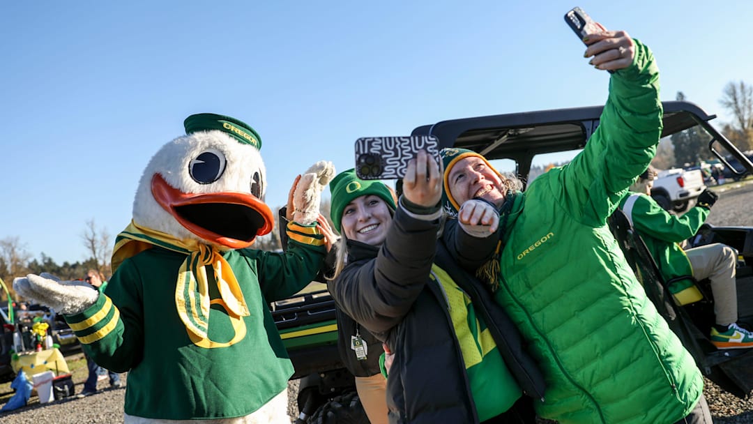 The Duck takes photos with Oregon fans. 