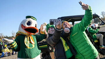 The Duck takes photos with Oregon fans. 