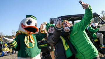 The Duck takes photos with with Oregon fans as they tailgate before the annual rivalry game on Friday, Nov. 24, 2023 at Autzen Stadium in Eugene, Ore.