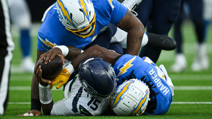 Aug 10, 2024; Inglewood, California, USA; Seattle Seahawks quarterback PJ Walker (15) is sacked by Los Angeles Chargers defensive tackle Jerrod Clark (72) and safety Thomas Harper (41) during the fourth quarter at SoFi Stadium. 