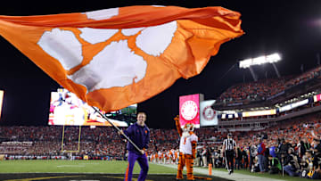 Jan 9, 2017; Tampa, FL, USA;  Clemson Tigers cheerleader waves a flag as mascot watches against the Alabama Crimson Tide in the 2017 College Football Playoff National Championship Game at Raymond James Stadium. Mandatory Credit: Kim Klement-Imagn Images