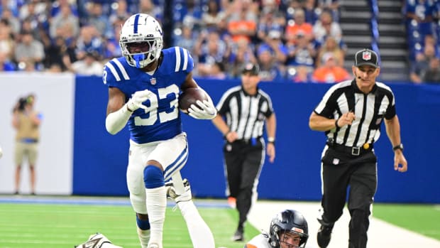 Colts cornerback Micah Abraham (blue jersey with white pants/helmet) runs the ball back after a fumble recovery. 