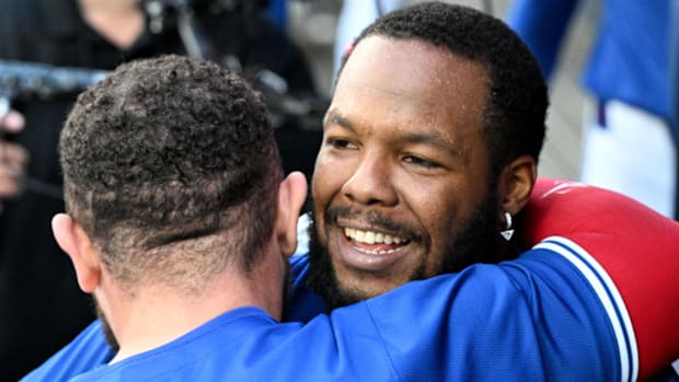 Vladimir Guerrero Jr. getting hugged by Alejandro Kirk