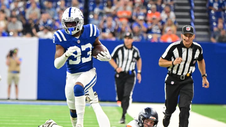 Aug 11, 2024; Indianapolis, Indiana, USA; Indianapolis Colts cornerback Micah Abraham (33) runs past Denver Broncos tight end Nate Adkins (45) for a touchdown during the second half at Lucas Oil Stadium. Mandatory Credit: Marc Lebryk-USA TODAY Sports