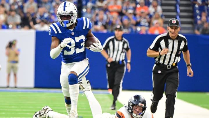 Aug 11, 2024; Indianapolis, Indiana, USA; Indianapolis Colts cornerback Micah Abraham (33) runs past Denver Broncos tight end Nate Adkins (45) for a touchdown during the second half at Lucas Oil Stadium. 