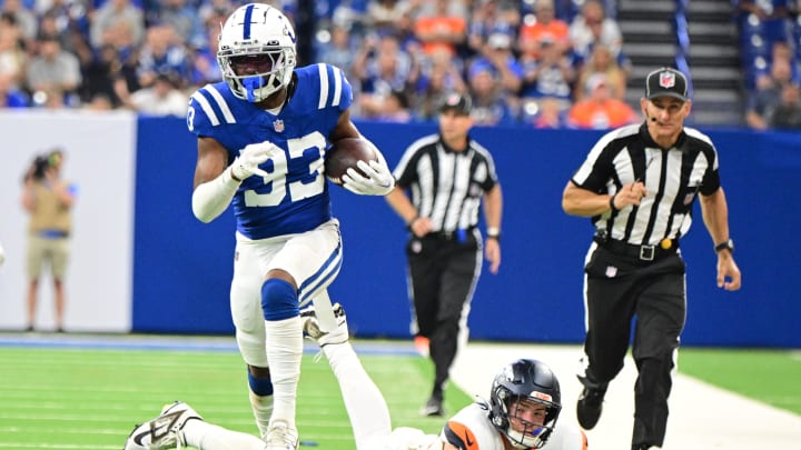 Aug 11, 2024; Indianapolis, Indiana, USA; Indianapolis Colts cornerback Micah Abraham (33) runs past Denver Broncos tight end Nate Adkins (45) for a touchdown during the second half at Lucas Oil Stadium. Mandatory Credit: Marc Lebryk-USA TODAY Sports