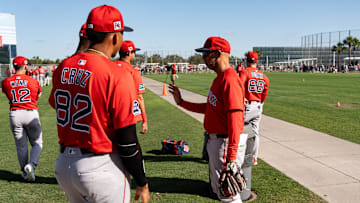 Alex Cora, center right, the manager of the Boston Red Sox interacts with players at JetBlue Park at Fenway South on Monday, Feb. 17, 2025.