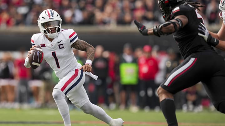 Nov 15, 2025; Cincinnati, Ohio, USA;  Arizona Wildcats quarterback Noah Fifita (1) runs with the ball as he looks to pass against the Cincinnati Bearcats in the first half at Nippert Stadium. Mandatory Credit: Aaron Doster-Imagn Images