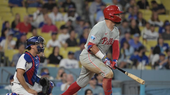 Aug 7, 2024; Los Angeles, California, USA;  Philadelphia Phillies designated hitter Kyle Schwarber (12) hits a solo home run, his third of the game, in the eighth inning against the Los Angeles Dodgers at Dodger Stadium. Mandatory Credit: Jayne Kamin-Oncea-USA TODAY Sports