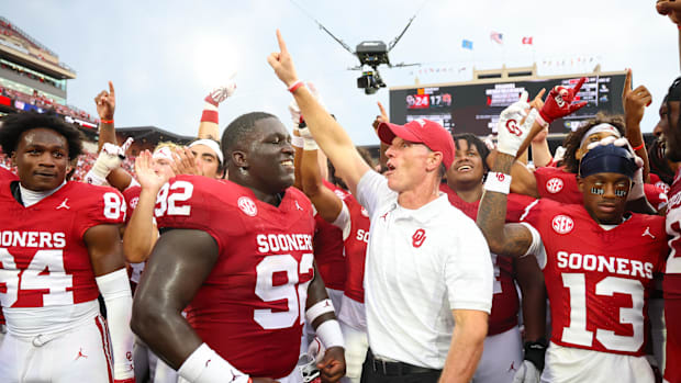 Oklahoma's Brent Venables celebrates with Sooners players after a win.