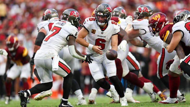 Tampa Bay Buccaneers quarterback Baker Mayfield (6) hands off to running back Bucky Irving (7)