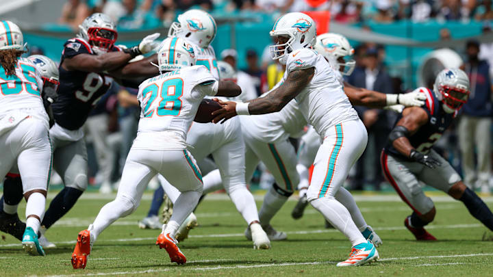 Miami Dolphins quarterback Tua Tagovailoa (1) hands off to running back De'Von Achane (28) in the second quarter at Hard Rock Stadium. 